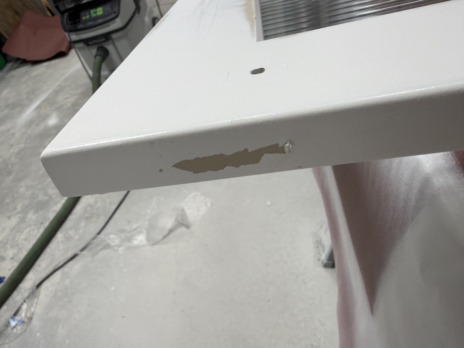 Old white coating peeling from the edge of a cabinet door