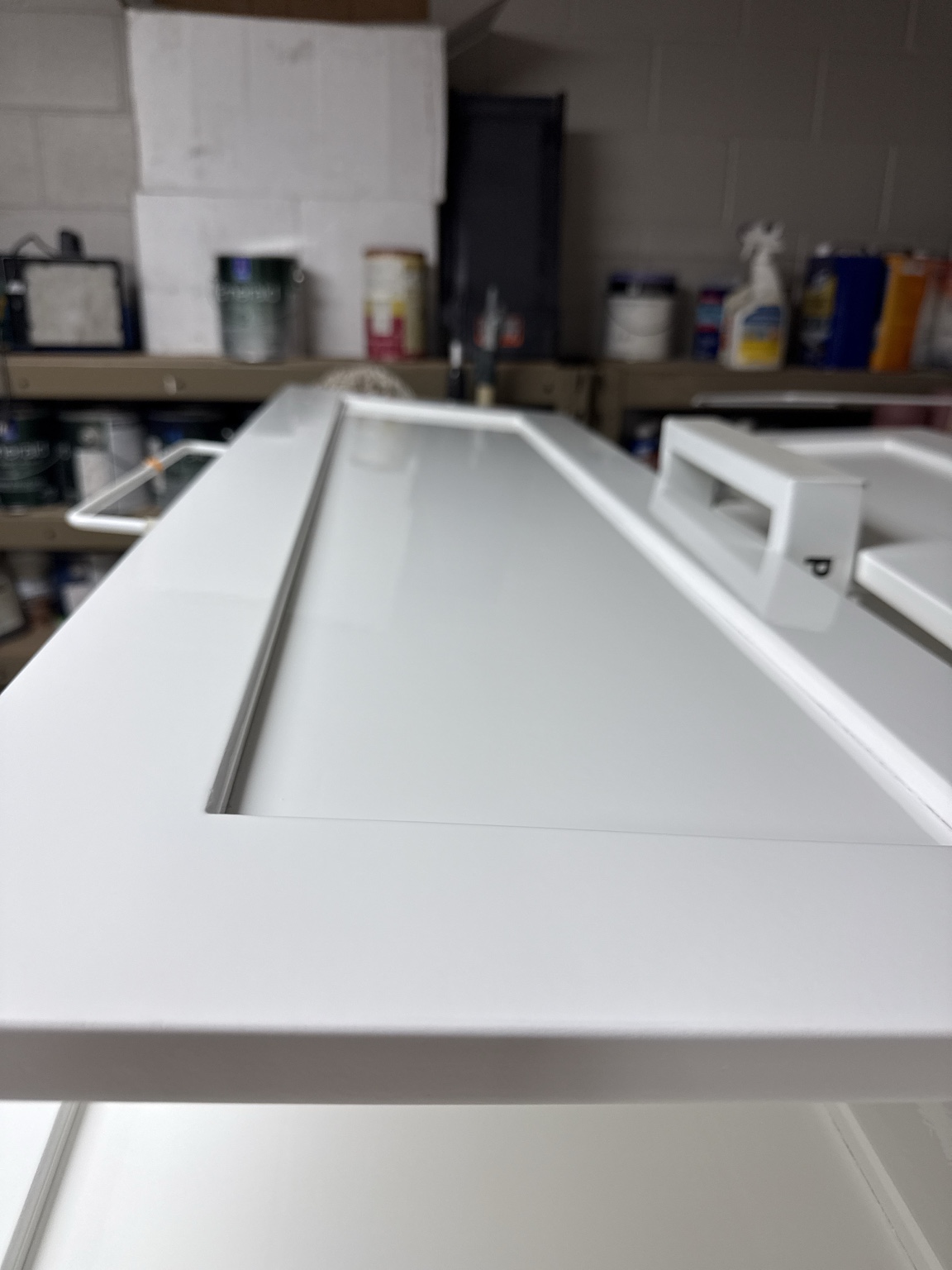 White refinished cabinet door resting on a drying rack