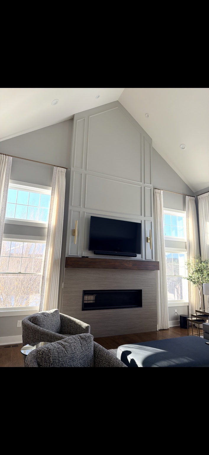 Painted living room walls and decorative trim above a wood-stained fireplace mantel